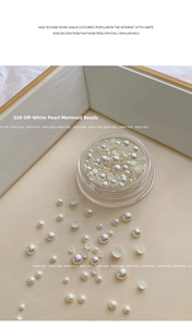 Macro detail of mixed size pearlescent white flatback pearls for nail art in wood tray