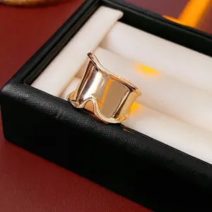 Modern wide gold wavy ring with mirror finish on luxury black leather jewelry box