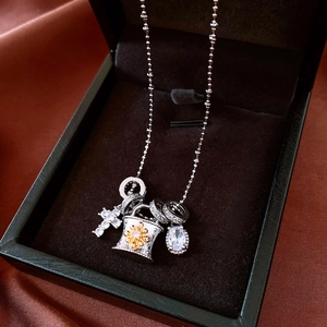 Dettaglio del ciondolo a croce in argento con charm girasole e pietra di zircone
