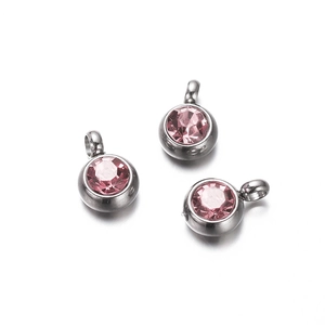 Detail of round pink cubic zirconia pendants with silver stainless steel bases for DIY jewelry