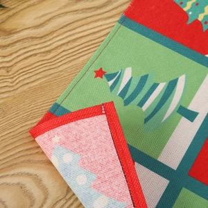 Close-up detail of textured Christmas placemat showing red stitched border