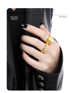 Close-up of golden chunky streamlined ring and twisted rope ring set on finger
