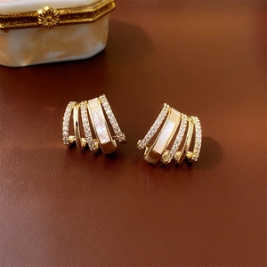 Elegant gold geometric claw earrings with white shell inlay and sparkling crystals