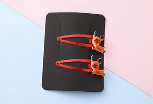 Detail view of two red glitter reindeer hair clips for Christmas on display card
