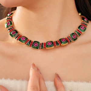 Detail of vintage square enamel necklace with green stones and red gems on gold-plated metal