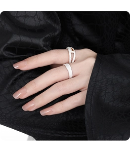 Detail of silver rings featuring irregular natural textures and brown gemstone inlay