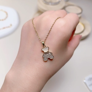 Titanium steel golden bear necklace featuring white shell and shimmering zircons for women