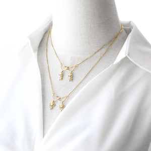 Gold-plated heart necklace with zircon-encrusted figures on a mannequin model