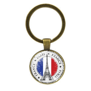Llavero de metal vintage con Torre Eiffel y bandera de Francia sobre fondo blanco