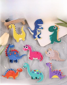 Set of nine colorful cartoon dinosaur embroidered patches with detailed 3D stitching