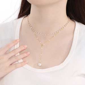 Close-up of double-layer gold Y-shaped necklace with elegant pearl tassels on a person