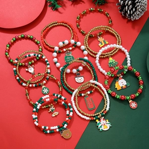 Christmas beaded bracelet set with Santa Claus, snowman, and elk pendants on holiday background