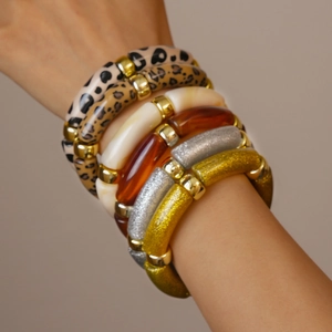 Stacked bamboo-style acrylic leopard print bracelets with gold spacer beads on wrist