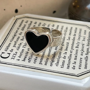 Macro shot of silver heart ring with black onyx inlay on elegant vintage box