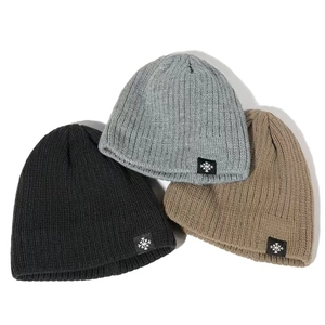 Close-up of thick knit beanies in black, gray and khaki with snowflake labels
