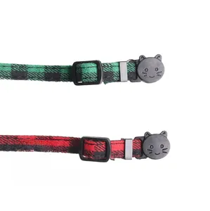 Detail view of British style red and green plaid cat collars with cat-shaped safety buckles