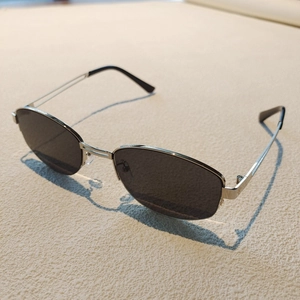 Classic silver metal frame sunglasses with black polarized lenses on a textured surface