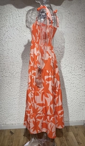 Detail of a tiered floral maxi dress with orange prints and elastic smocked bodice