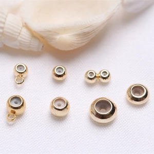 Macro detail of 14k gold-filled silicone slide beads for DIY jewelry making and positioning