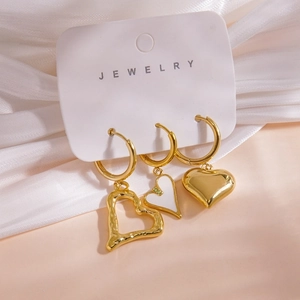 Detailed shot of a 3-piece 14K gold plated heart earring set with enamel and zircon inlay