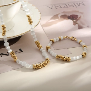 Détail de l'ensemble collier et bracelet bohème en perles d'œil de chat avec accents dorés