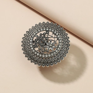 Macro shot of retro silver hollow flower ring featuring intricate metallic details