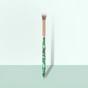 Detail of eyeshadow blending brush with green glitter handle and rose gold ferrule