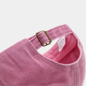 Dettaglio del berretto in velluto rosa con fibbia in bronzo retrò e trama del tessuto