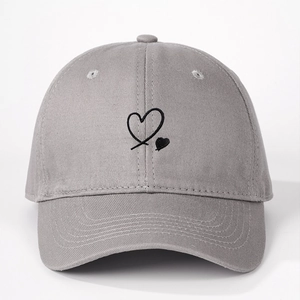 Detailed close-up of gray cotton baseball cap featuring black heart embroidery and twill texture
