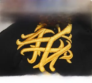 Detailaufnahme der hochdichten 3D-Goldstickerei auf der schwarzen Mesh-Baseballkappe