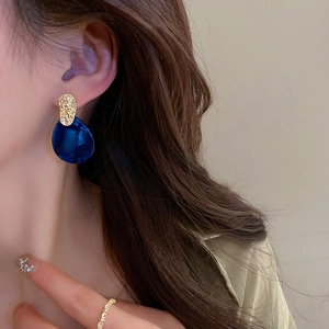 Vintage acrylic teardrop earrings with gold textured metal tops on female model