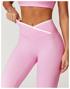 Detail van een roze yogabroek met een stijlvolle V-vormige hoge tailleband en witte bies