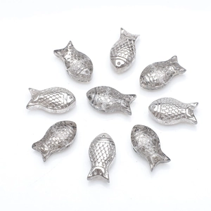 Macro detail of silver fish-shaped glass beads with textured scales for DIY jewelry making