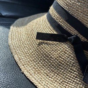 Detailansicht eines handgewebten Bast-Sonnenhutes mit elegantem schwarzen Satinband
