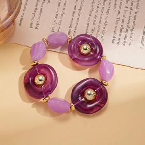 Detail of purple acrylic resin beads and golden metal spacers on a vintage necklace