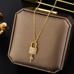 Gold plated lock and key pendant necklace with crystals on a brown jewelry box