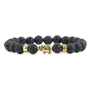 Detailed close-up of a black lava stone beaded bracelet with a decorative gold elephant
