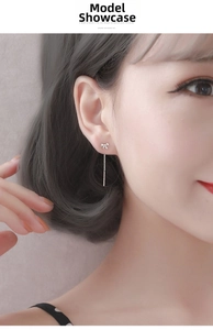 Close-up of S999 sterling silver bow tassel earrings on model showing fine chain details