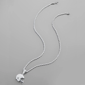 Détail macro du pendentif casque de rugby argenté avec strass brillants sur chaîne torsadée
