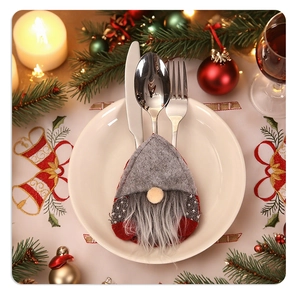 Christmas gnome cutlery holder with grey felt and beard on a festive holiday dinner plate