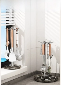 Close-up of rotating kitchen utensil rack with stainless steel hooks and drip tray
