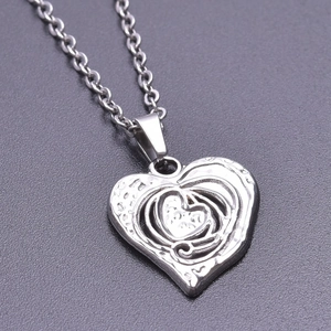 Macro shot of silver stainless steel nested heart pendant with vintage textured inner finish