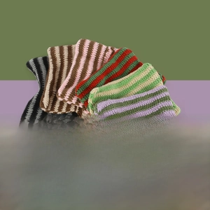 Macro detail of striped knit beanies with cat ears in five vintage color patterns