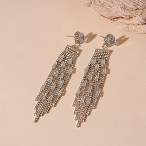 Macro detail of long silver fringe earrings with sparkling tassel zirconia on stone