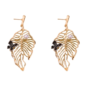 Elegant gold leaf earrings with black butterfly and white pearl detail on white background