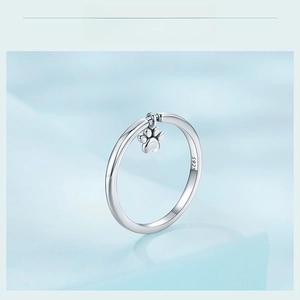Macro shot of 925 sterling silver ring featuring a cute hanging dog paw print charm