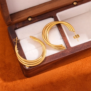 Χρυσά σκουλαρίκια κρίκοι τριών στρωμάτων από ανοξείδωτο ατσάλι σε ξύλινη κοσμηματοθήκη