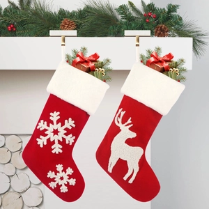 Large knitted Christmas stockings with reindeer and snowflake patterns hanging on a mantel