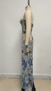 Detail der schweren Blumenstickerei und blauen Pailletten am Abendkleid aus Netzstoff