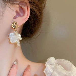 Elegant acrylic petal drop earrings in gold and translucent white on female model